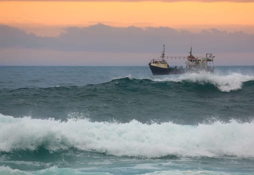 Fishing trawler off the coast off South Africa at sunset
