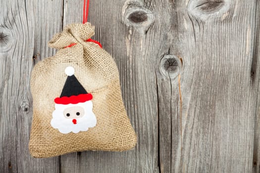 Rustic Christmas background with text space with a small jute sack on rustic wooden background