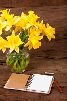 Open a notebook and lay a pen on a wooden surface