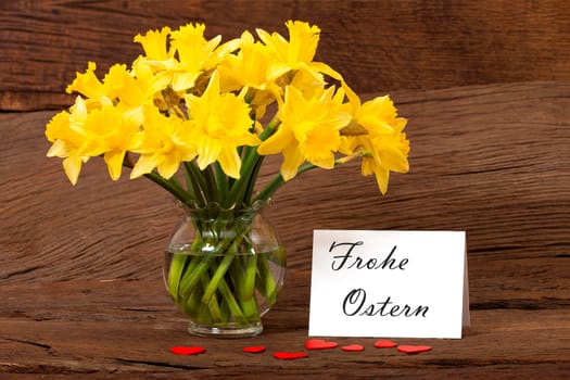 Easter greetings on a card with a bouquet of daffodils in the vase