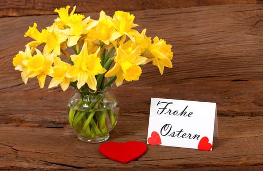 Easter greetings on a card with a bouquet of daffodils in the vase
