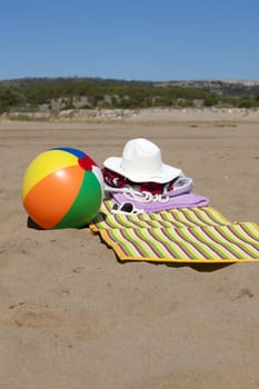 With beach mat,straw hat,sunglasses and water polo on the beach