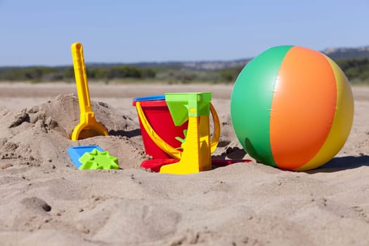 Colorful beach toys on the sandy beach