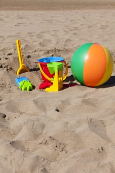 Colorful children's toys on the beach with text space in the upper and lower part of the picture