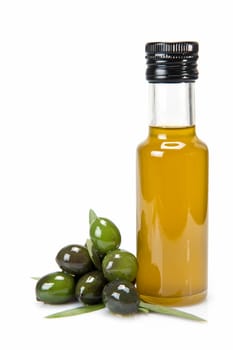 Glass bottle of premium virgin olive oil and some olives with leaves isolated on a white background