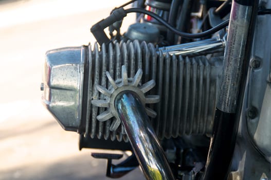 Detail of old, weathered, vintage motorcycle engine cylinder, showing corrosion and bluing of the exhaust pipes.