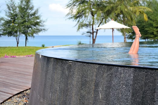 A girl's feet stand out of an infinity pool