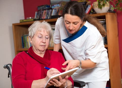 Nurse helps senior citizen with a form