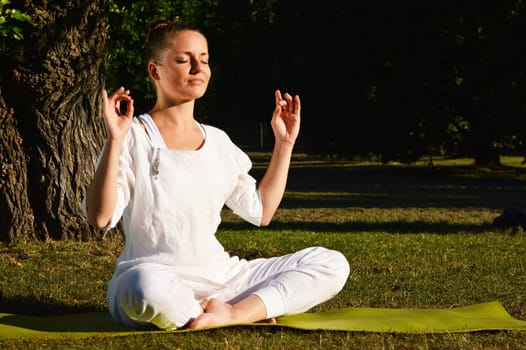 Young woman during yoga meditation in the park