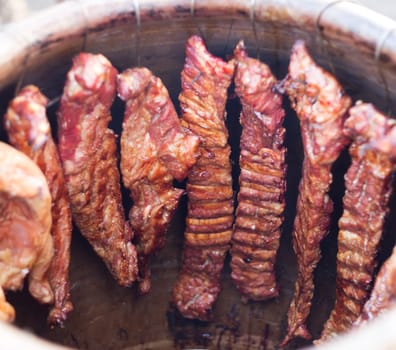 ribs roasting in a clay barrel in thailand market night market