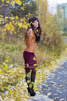 The beautiful girl in the autumn forest smiling