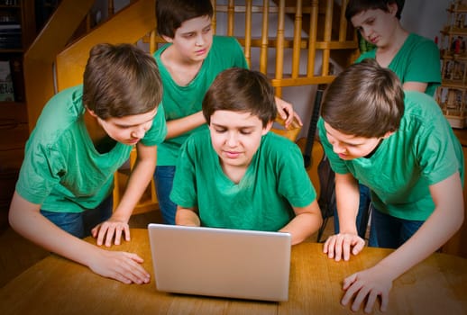 Multiple exposure of a young male teenager in a green T-shirt at the table with notebook in different poses