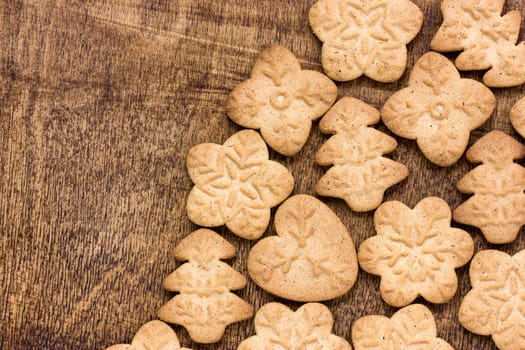 Homemade various christmas gingerbread cookies on wooden background with copy space