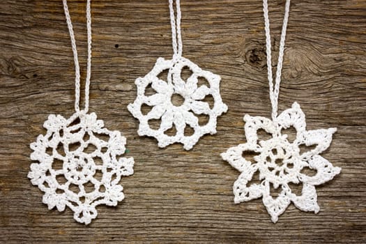 Crochet christmas snowflakes hanging on wooden wall
