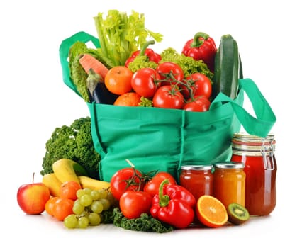 Green shopping bag with variety of fresh organic vegetables isolated on white
