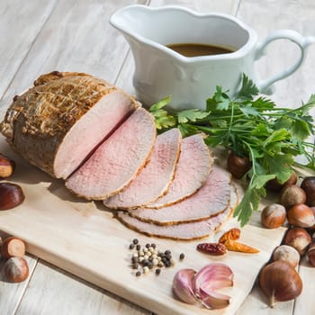Sliced roast beef with some ingredients on the table of the kitchen