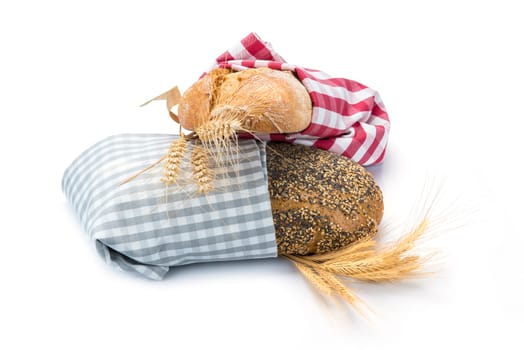 Bread assortment decorated with cereal ears and isolated over a white background