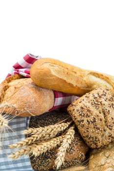 Bread assortment decorated with cereal ears and isolated over a white background