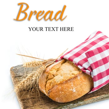 Wheat bread with ears on a cutting board isolated on a white background