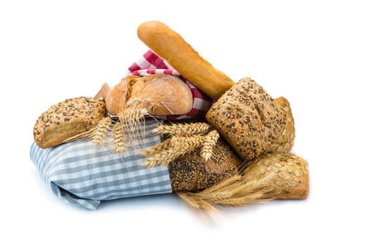 Bread assortment decorated with cereal ears and isolated over a white background