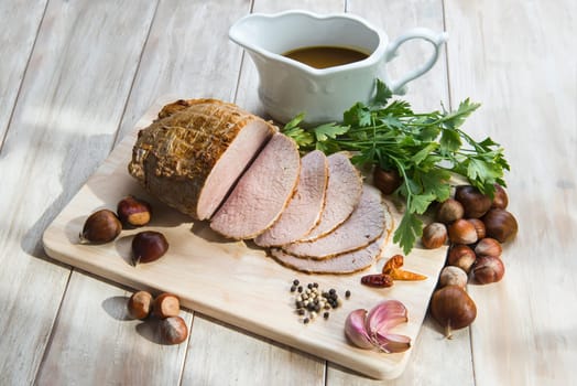Sliced roast beef with some ingredients on the table of the kitchen