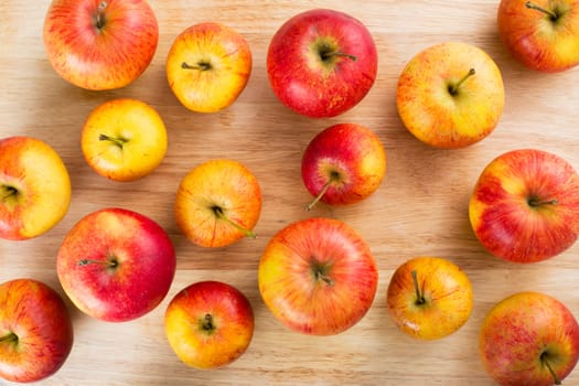 Red and yellow apples on table viewed from above.