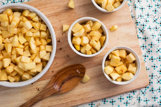 Chopped apples with sugar and spices in baking dishes.