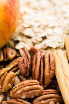 Ingredients for baking, pecans with cinnamon sticks and othe ingredients for apple crumble
