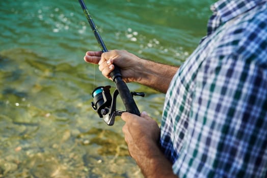 mid adult man on holidays on river, relaxing and fishing trout