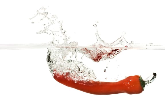 Close up on Red pepper splashing into water isolated on white