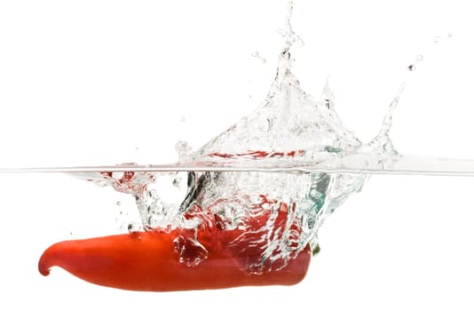 Close up on Red pepper splashing into water isolated on white