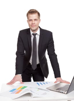 Handsome businessman standing behind the office desk