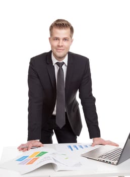 Handsome businessman standing behind the office desk