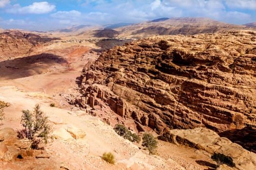 View of desert and ancient tombs carved in the rock in Petra, Jordan