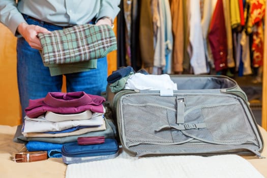 A man is packing suitcase at home for a business trip