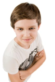 Upper body portrait of a young male teenager in a T-shirt and crossed arms in front of a white background smiling at the camera from an elevated view