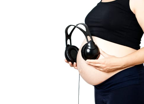 Pregnant woman with headphones on belly