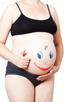 Painted happy smiley face on the belly of pregnant woman