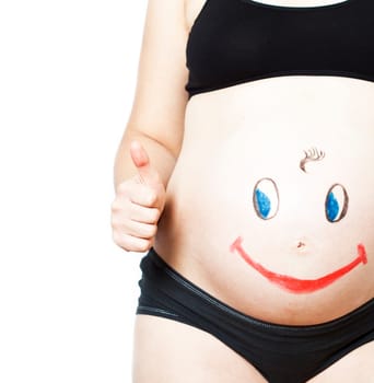 Painted happy smiley face on the belly of pregnant woman