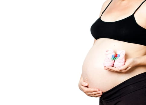 Pregnant woman with baby shoes isolated on white