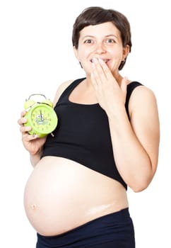 Happy pregnant woman with an alarm clock