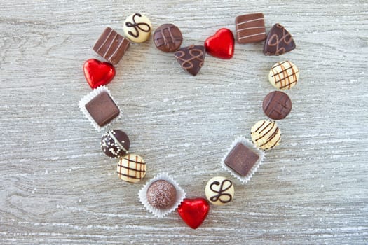 Heart shape made of various pralines and chocolates