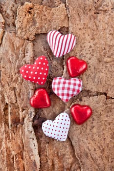 Small red hearts and chocolate on rustic background