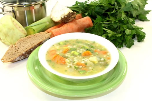 a white bowl of colorful pearl barley soup