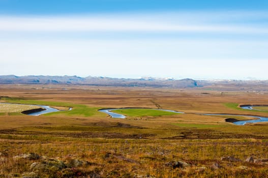 Icelandic landscape with volcanic rocks and green grass