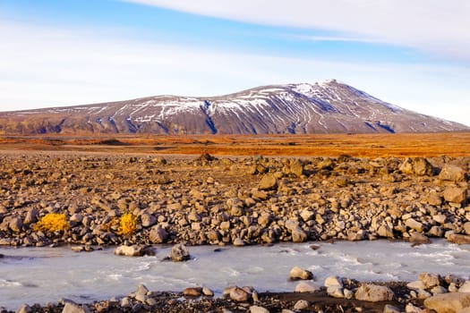 Icelandic landscape with volcanic rocks and green grass