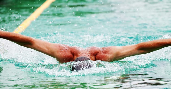 Swimmer performing the butterfly stroke  in olimpic basin