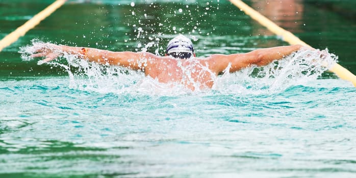 Swimmer performing the butterfly stroke  in olimpic basin