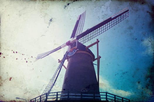 Vintage photo of dutch windmill under the blue sky of Netherlands