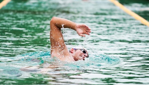 Young man swimming the front crawl in a pool